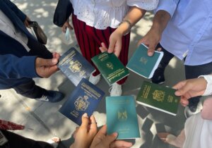 People of various nationalities holding out their varying passports