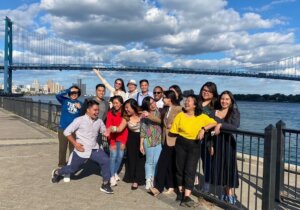 People posing in front of a bridge